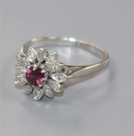A modern 18ct white gold, ruby and diamond cluster flower head ring, size N.